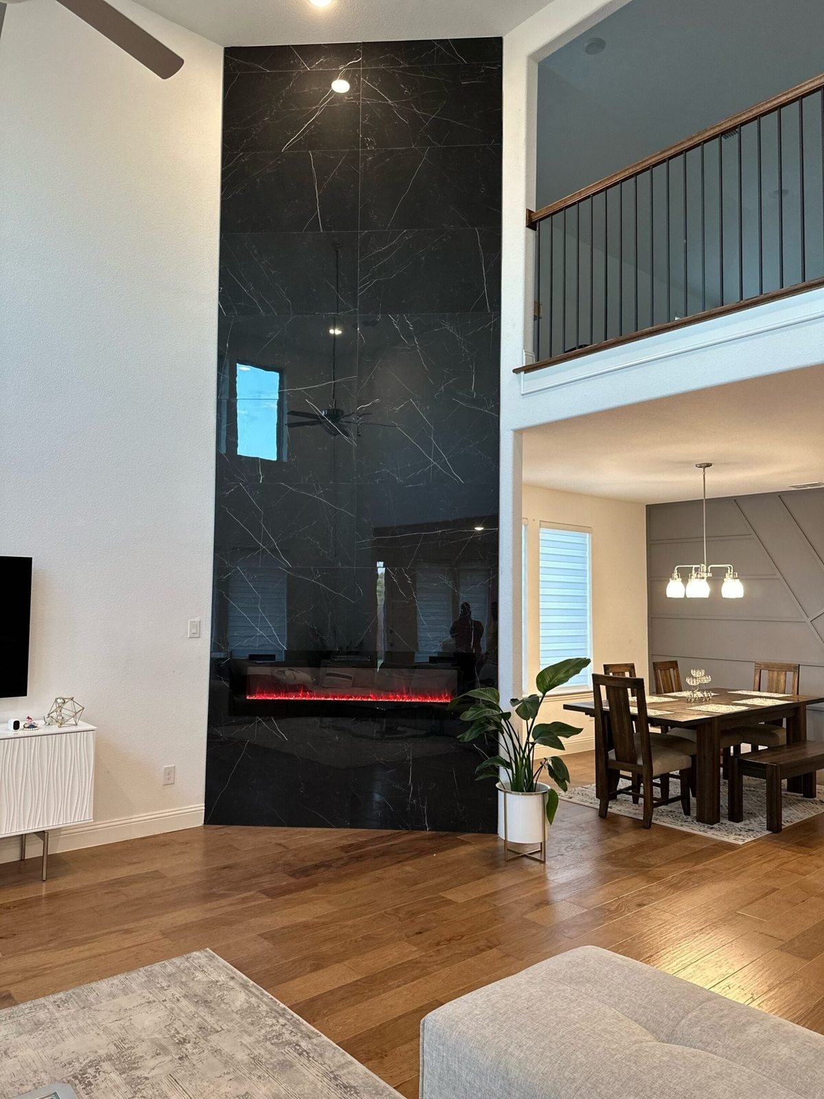 Tall dark fireplace feature wall beside a staircase and living area